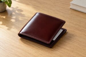 木の机に置いた赤茶のコードバンの小さな二つ折り財布